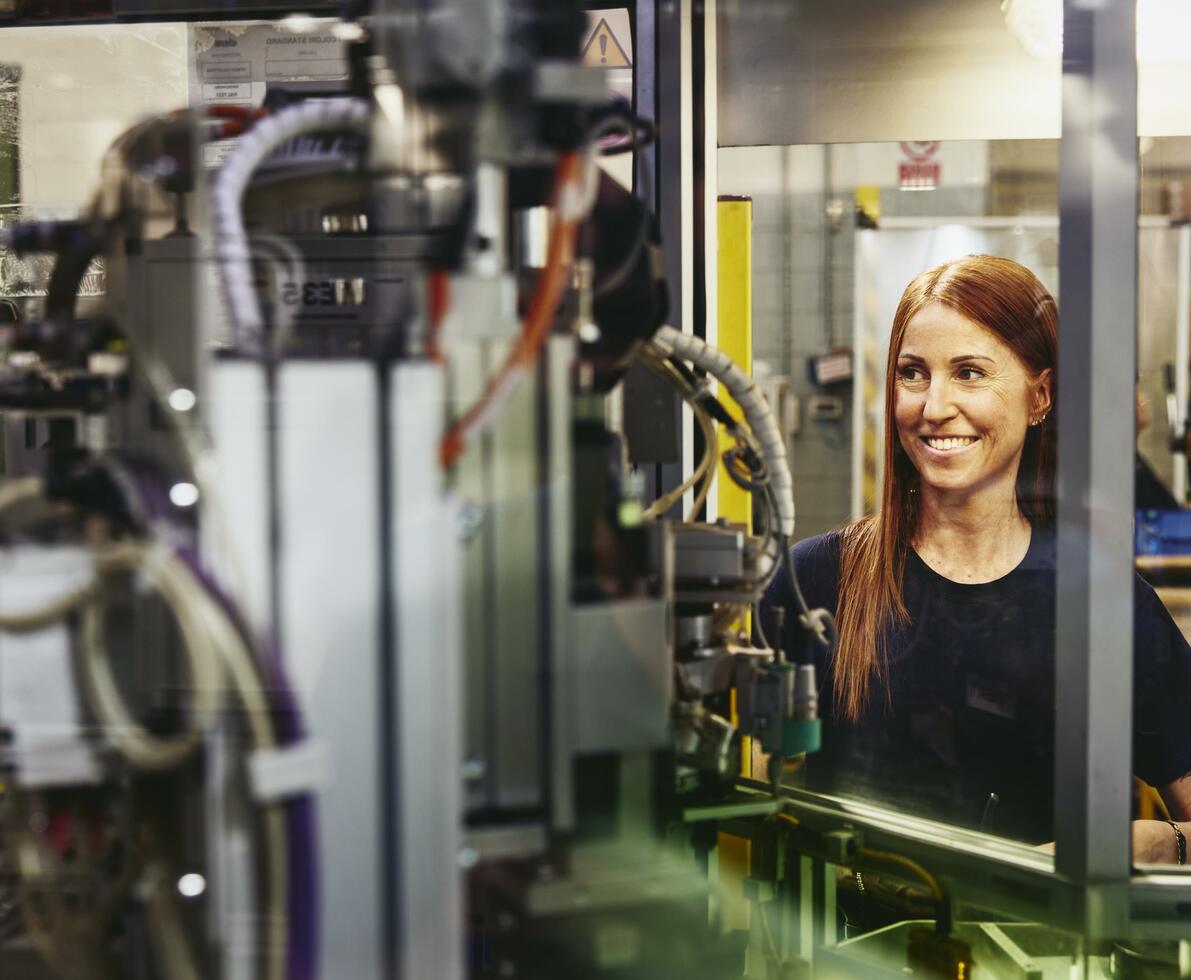 Woman operating a machine on a production site. veiligheidstrainingen