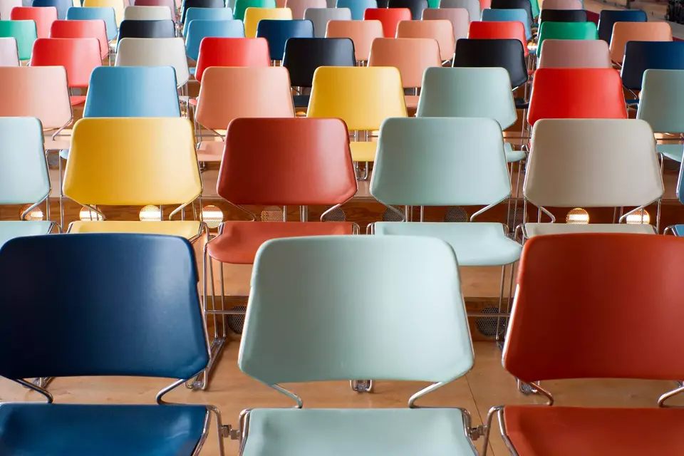 Rows of colorful empty chairs in a theater